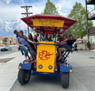 Group smiling on a pedal pub